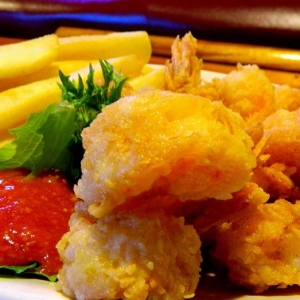 Closeup of large fried shimp and fries