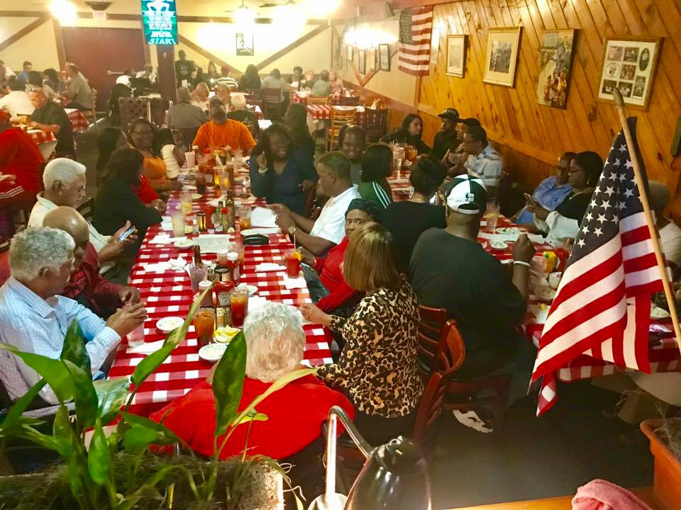 Large party of people sitting together at dining table